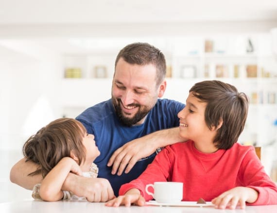 Dad and two young kids at kitchen counter