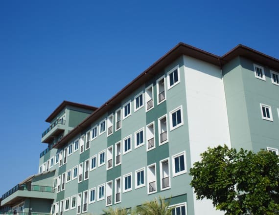 Modern apartment building with trees outside, on a sunny day