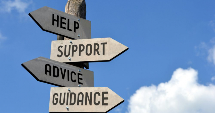 Signpost, seen in front of a blue sky, with signs pointing to "Help," "Support," "Advice," and "Guidance"